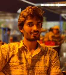 a man with a beard wears a yellow shirt with a pattern on it