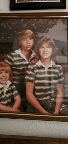 a framed photo of a boy and two girls taken by jimmy