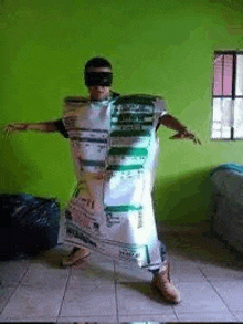 a man is standing in a room wearing a costume made out of a trash bag .