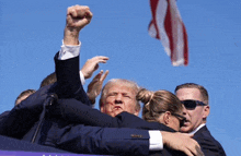 a man with a fist in the air surrounded by people