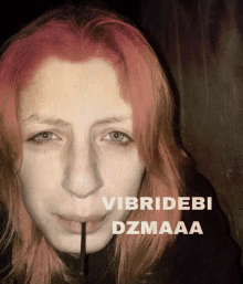 a woman with red hair is holding a straw in her mouth and the words vibridebi dzmaaa are above her face