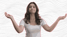 a woman in a white shirt with her arms outstretched making a face