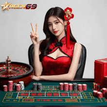 a woman in a red dress is sitting at a table with chips and a roulette wheel in front of a sign that says agengg