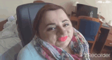 a woman wearing pink lipstick and a scarf is sitting in a chair in a room .