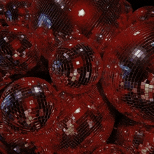 a bunch of red disco balls are stacked together