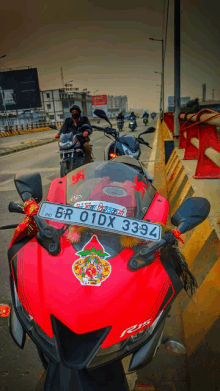 a red motorcycle with a license plate that says br 01dx 3393