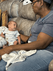 a woman is holding a baby on her lap