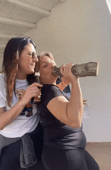 a woman wearing a polo bear t-shirt is drinking from a log