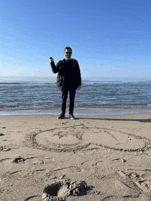 a man stands on the beach with a circle drawn in the sand