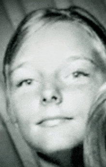 a black and white photo of a young woman 's face .