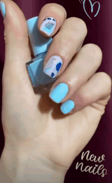 a close up of a woman 's hand with blue nails and a bottle of nail polish