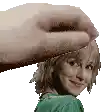 a hand is touching a woman 's head .