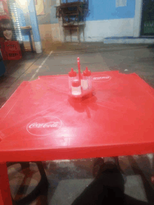 a red table with a coca-cola sticker on it