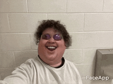 a fat man wearing sunglasses is taking a selfie in a public restroom .