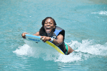 a woman is riding a surfboard that says sander