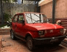 a red car is parked in front of a building .