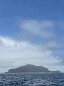 a large body of water with a mountain in the background