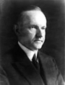 a black and white portrait of a man in a suit and tie .