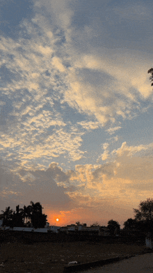 a sunset with a lot of clouds and buildings in the foreground