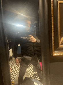 a man taking a picture of himself in a mirror wearing a black shirt that says " 2mo12и3 "