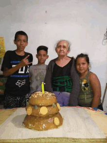 a boy wearing a shirt that says fox is standing next to a woman and two children