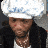 a man wearing a shower cap and ear buds is looking at the camera .