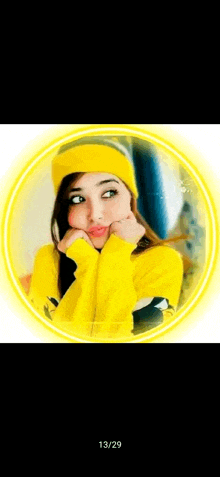 a girl wearing a yellow hat and a yellow sweater is making a face .