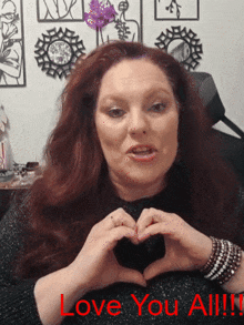 a woman making a heart shape with her hands and the words love you all written below her