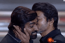 two men kissing in front of a screen that says ' gtv hd '