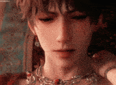 a close up of a person 's face wearing a necklace and earrings