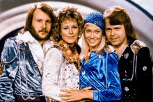 a group of four people posing for a picture with one wearing a blue and white outfit