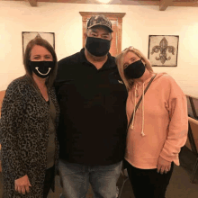 a man and two women wearing face masks are posing for a picture