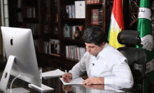 a man sits at a desk with an apple computer