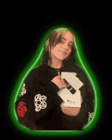 billie eilish is holding a trophy in front of a green glow