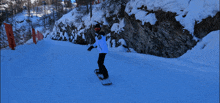 a person riding a snowboard down a snow covered slope