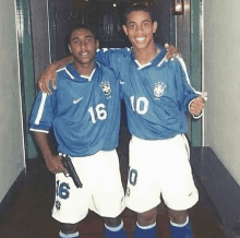 two soccer players are posing for a picture and one has a gun in his pocket