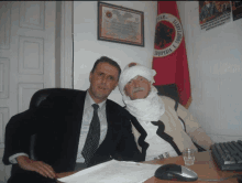 two men are posing for a picture in front of a flag that says " kosoveria "