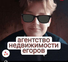 a man wearing sunglasses with the words агентство недвижимости егоров written below him