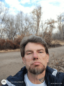 a man with a tattoo on his neck is taking a selfie