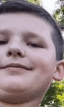 a close up of a young boy 's face smiling .