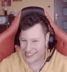 a young man wearing headphones is sitting in a red chair .