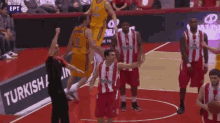 a group of basketball players on a court with a turkish airlines banner in the background