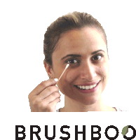 a woman is smiling while holding a cotton swab in front of the word brushboo