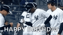 a group of baseball players are standing next to each other on a field and they are saying happy birthday .