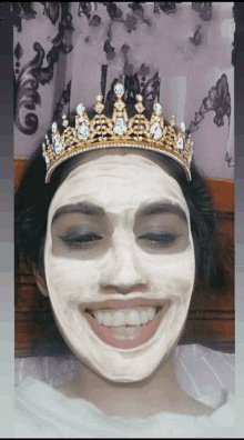 a woman wearing a crown and a white mask on her face