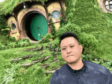 a man stands in front of a hobbit house