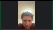 a man with curly hair is looking at the camera with a green border around his face