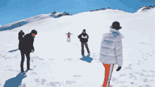 a group of people standing on top of a snow covered mountain with the word tommy on the bottom left