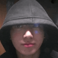 a close up of a person wearing a hooded sweatshirt and a hat .