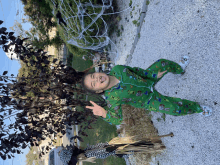 a little boy wearing a green pajama set with minecraft on it is giving a peace sign